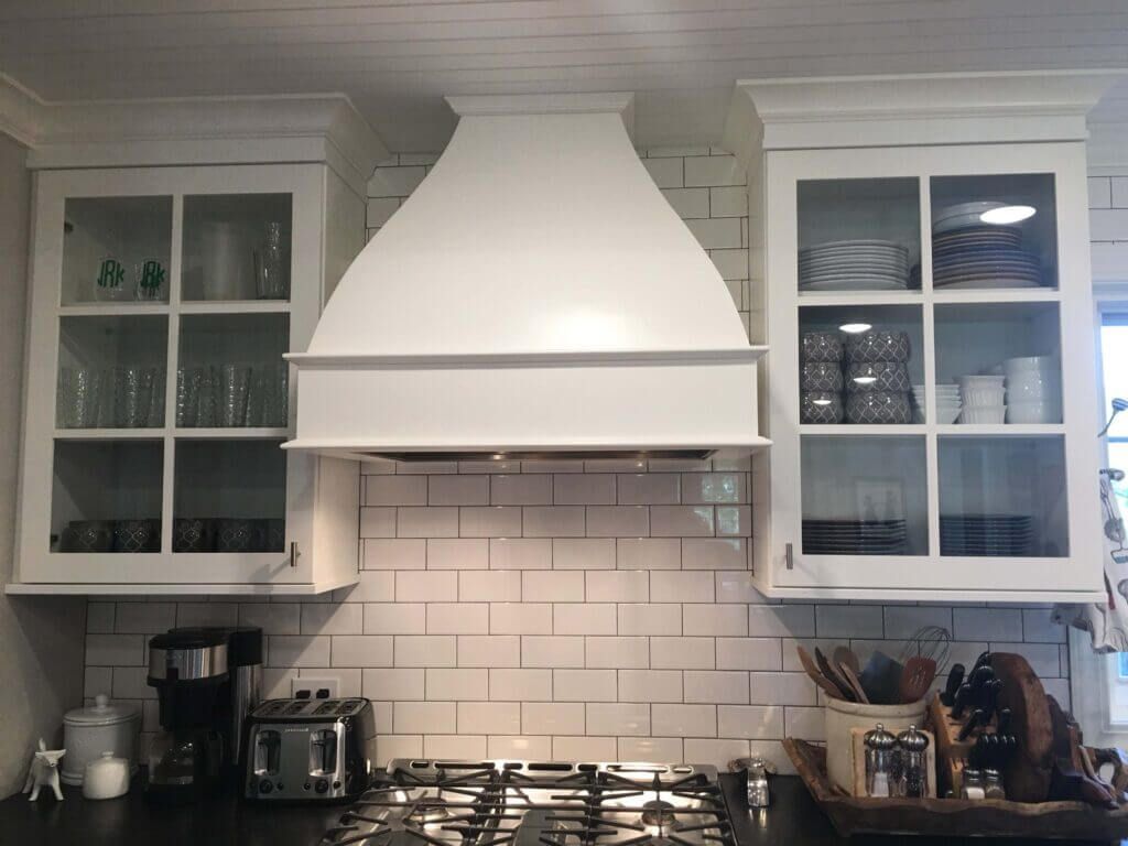 A custom kitchen with white cabinets and range hood in Fulton MO. 