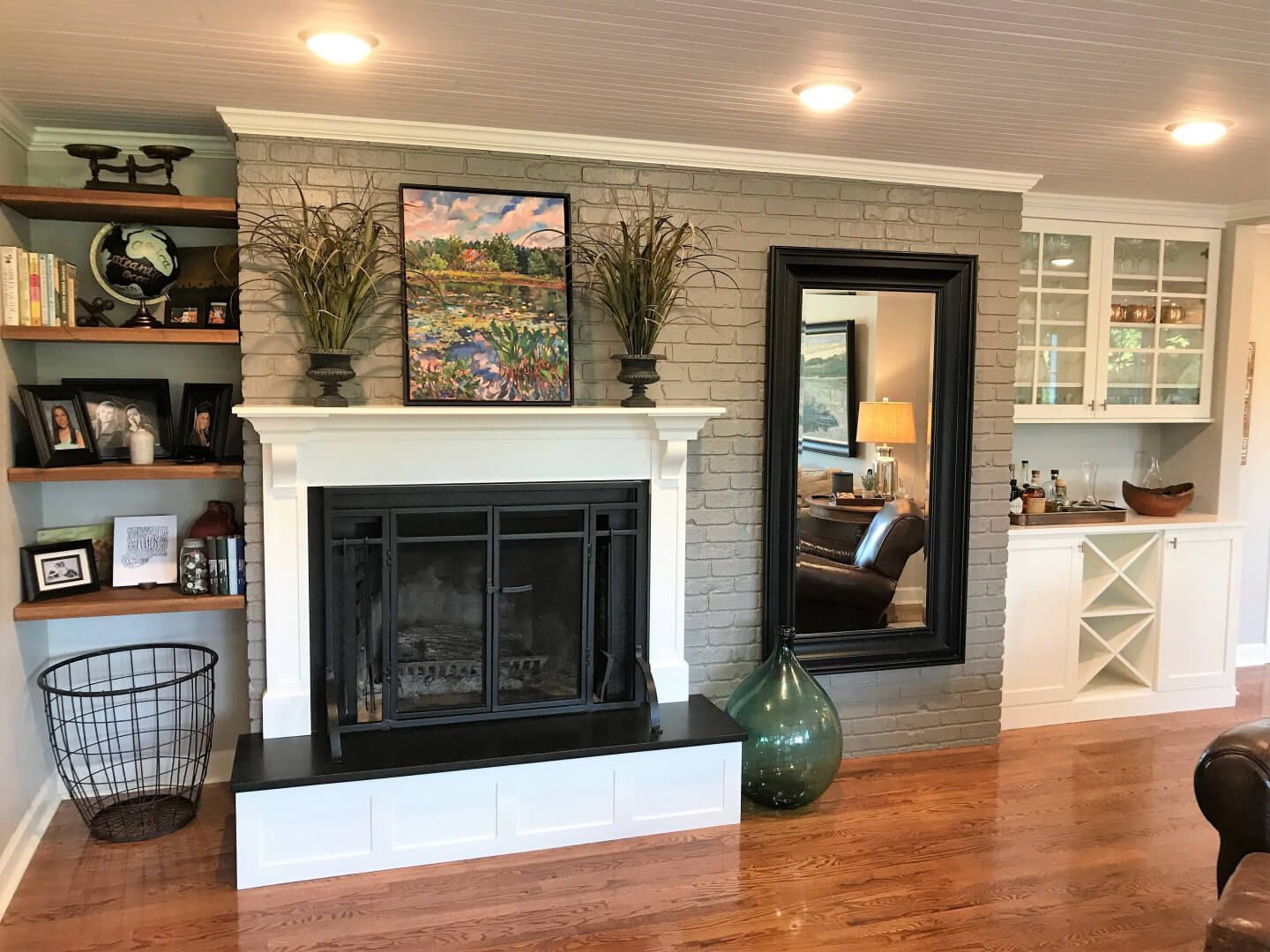 A living room with a fireplace and a mirror. Custom cabinets Columbia Missouri 