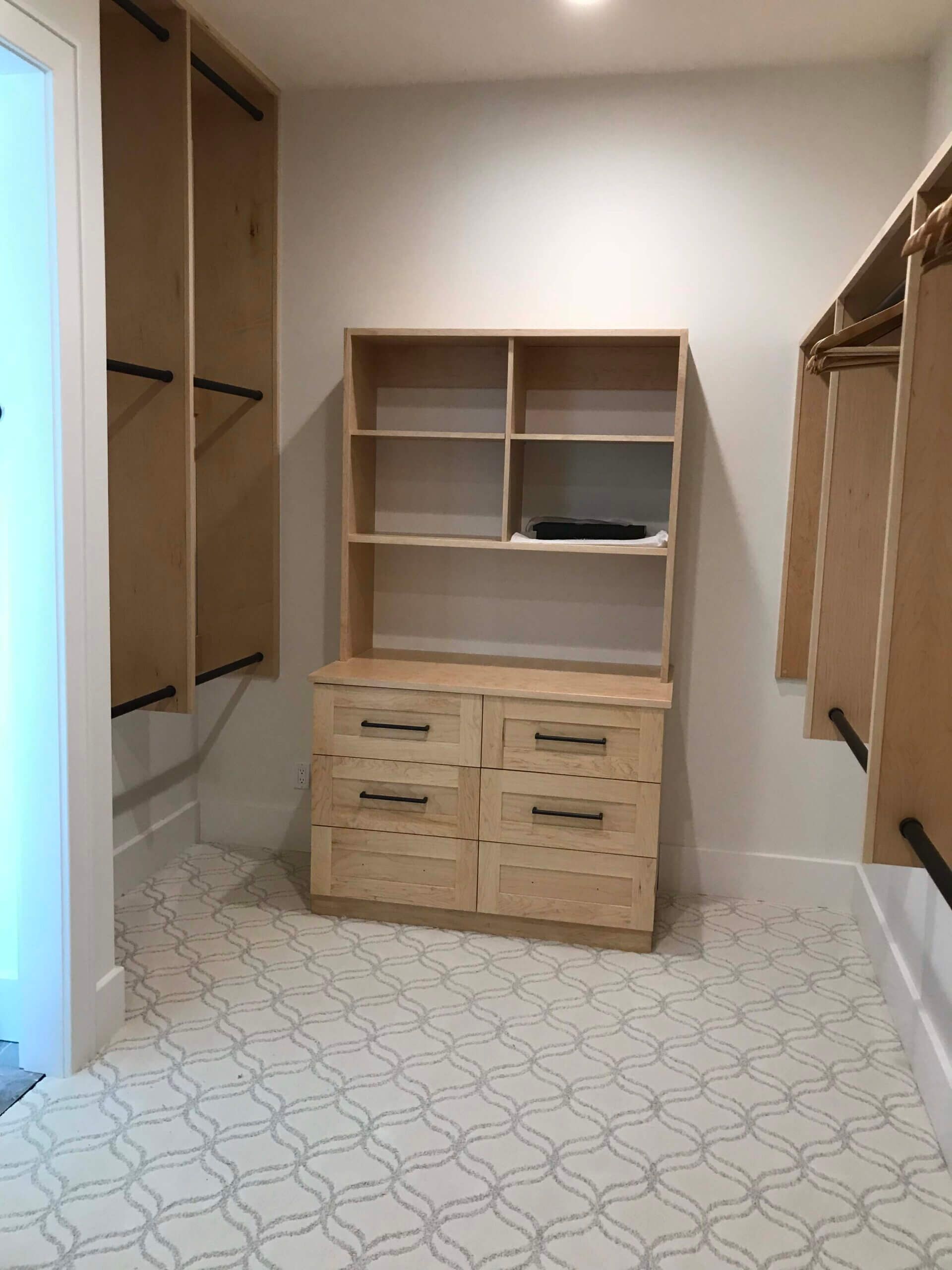 A custom walk in closet with a wooden dresser and shelves. Columbia MO.