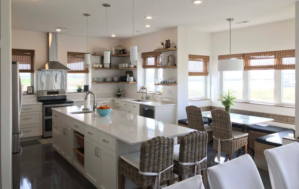 A kitchen with a large island and wicker chairs, Custom cabinets Columbia Missouri 
