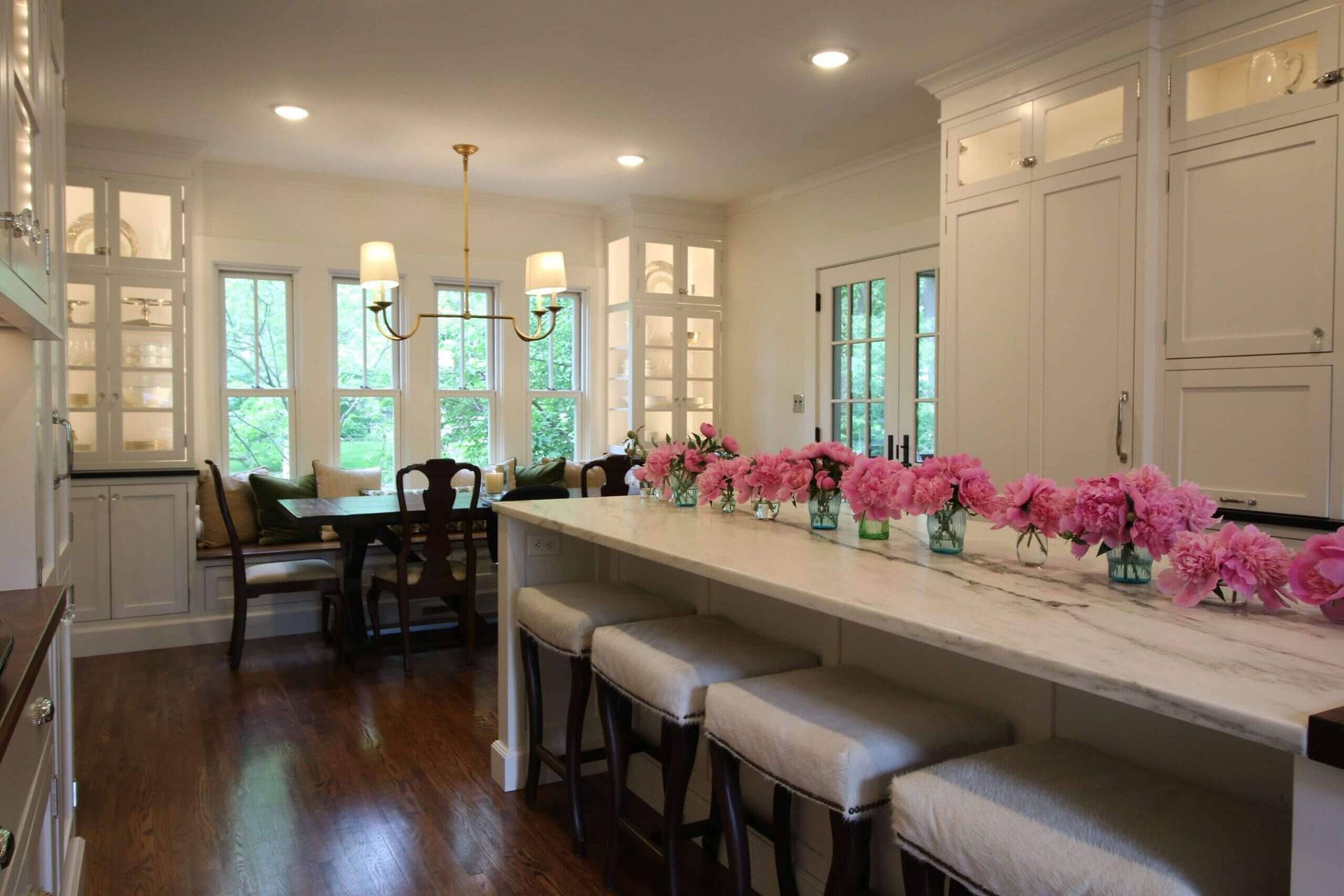 A custom kitchen with a long island and a table with pink flowers on it. Custom cabinets Columbia Missouri 