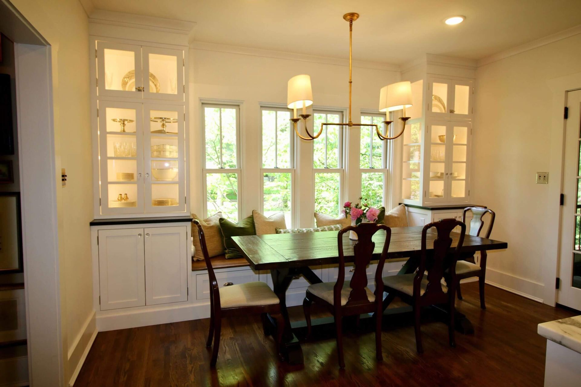 A custom dining room with a table and chairs and a chandelier. Custom cabinets Columbia Missouri 