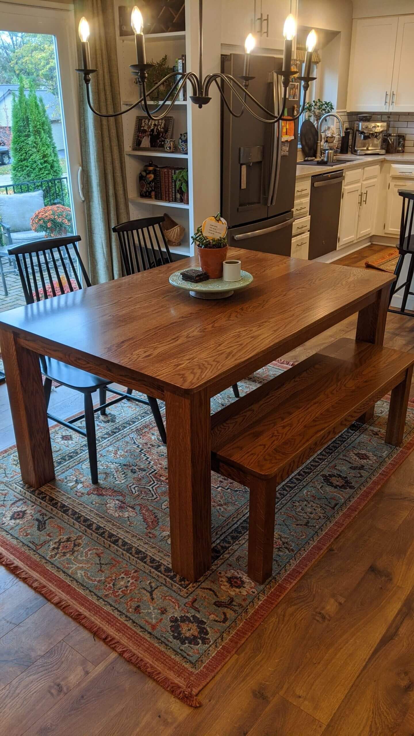 A custom wooden dining table with a bench and chairs in a kitchen in a Columbia Missouri home. 