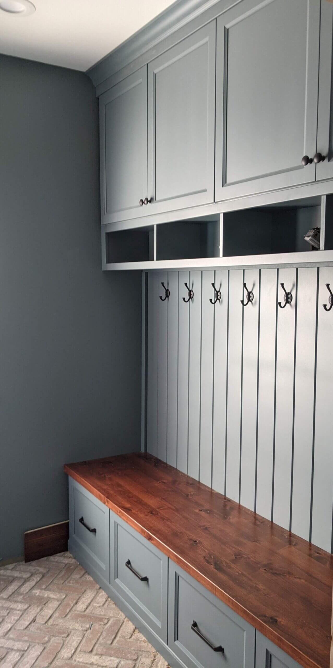 A mud room with a bench and hooks on the wall. Custom cabinets Columbia Missouri 
