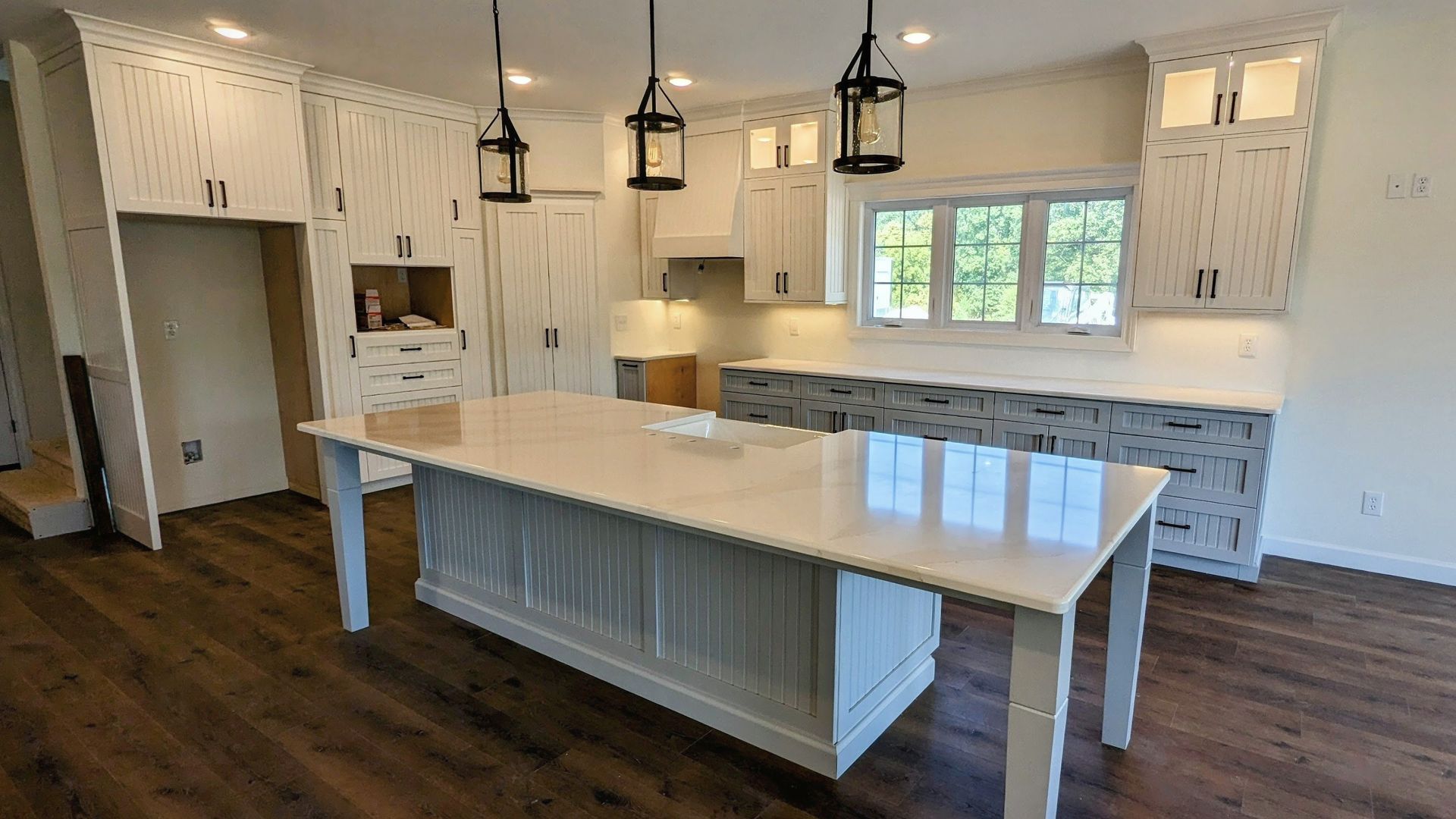 Large custom kitchen island with beadboard detailing and white inset cabinetry in Mid-Missouri. Custom cabinets Columbia Missouri 