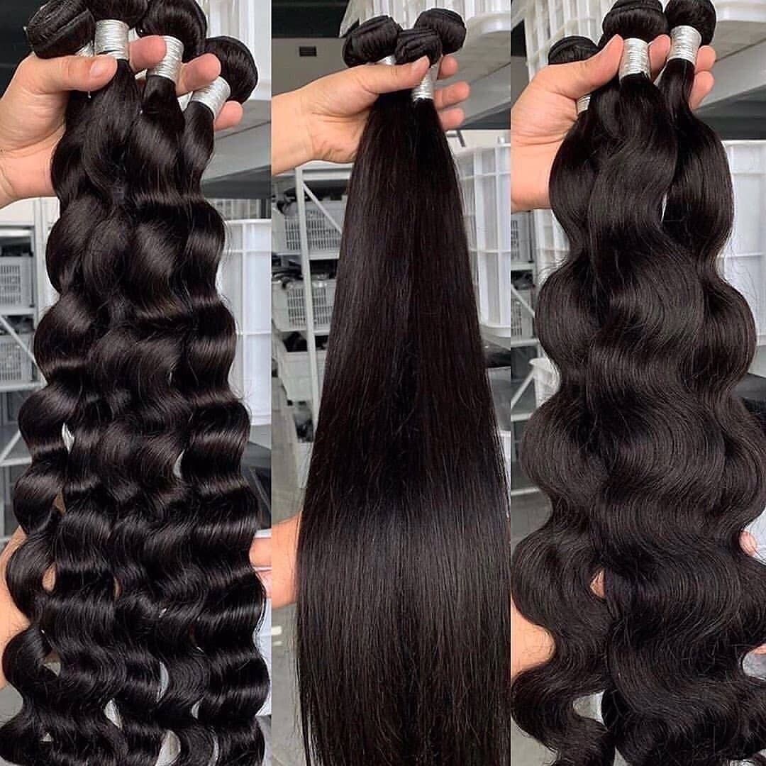 Three bundles of black human hair extensions: curly, straight, and wavy, held by hands.