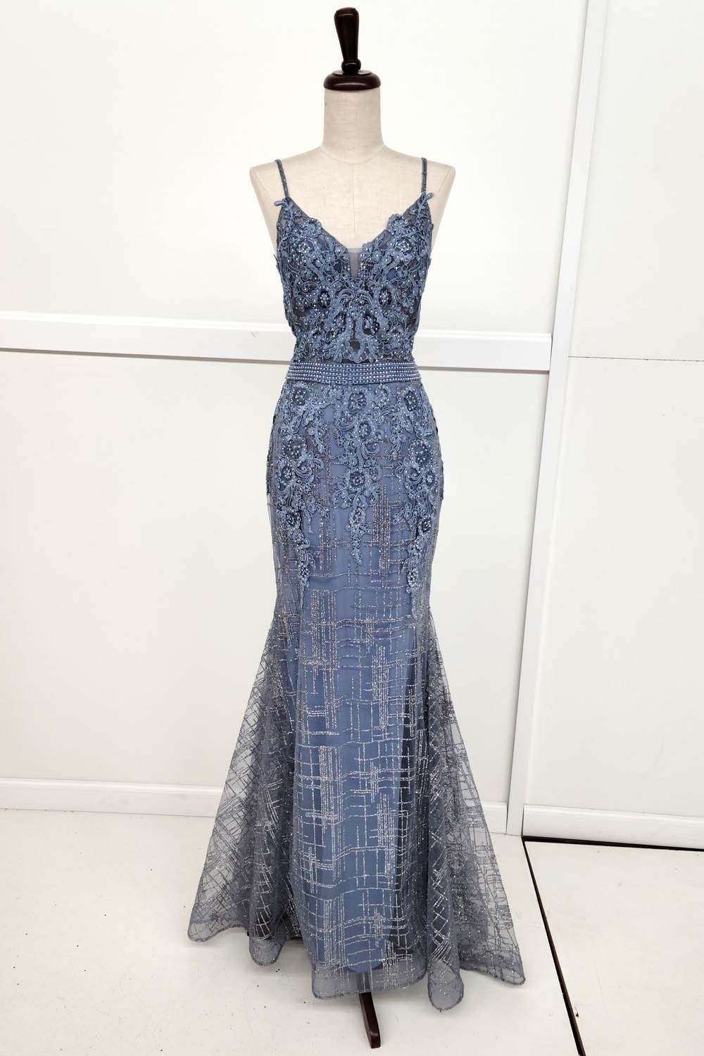 Blue beaded mermaid gown on a mannequin, thin straps, V-neck, floor-length.