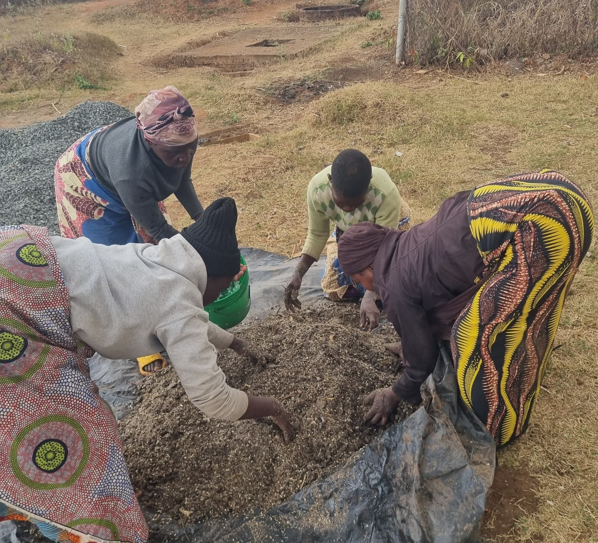 Women from Sakata village, Zomba District, work together to prepare organic fertiliser from locally available materials during regenerative agriculture training delivered through The Sparkle Foundation's Spark to Success programme.