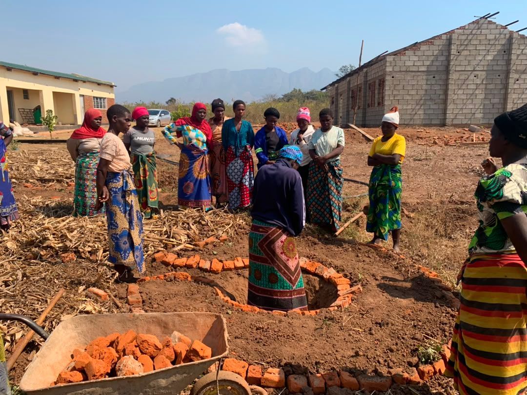 Women from Sakata village, Zomba District, take part in hands on regenerative agriculture training, working together to prepare a growing bed using locally available materials as part of The Sparkle Foundation's Spark to Success programme.