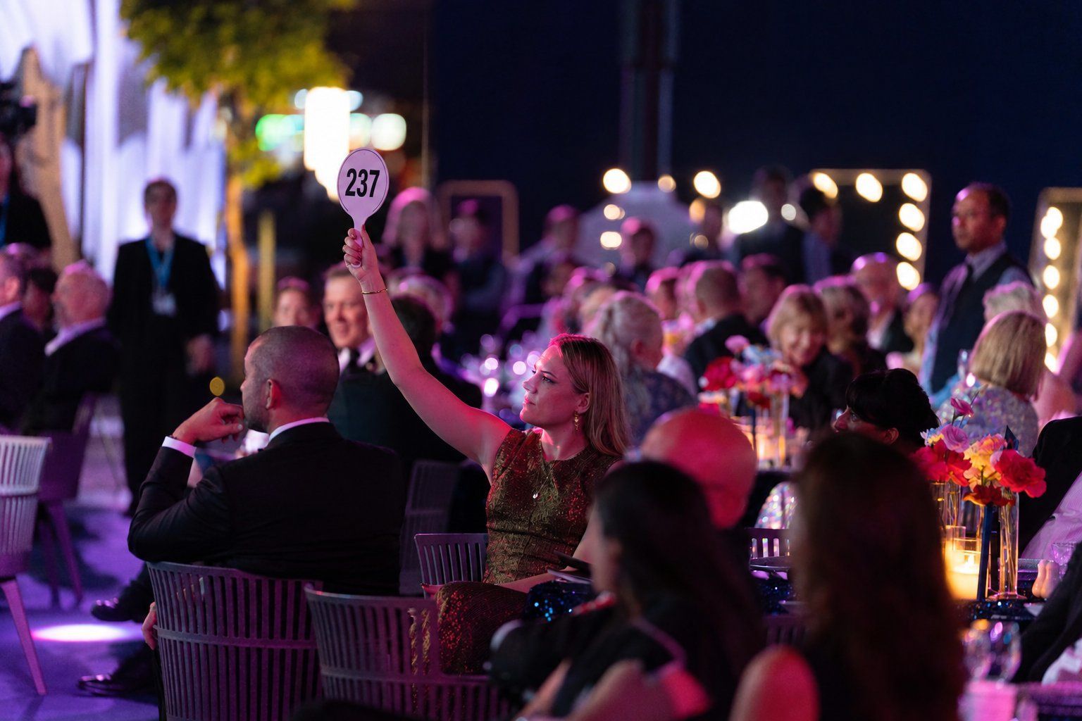 A guest raising her paddle during the live auction