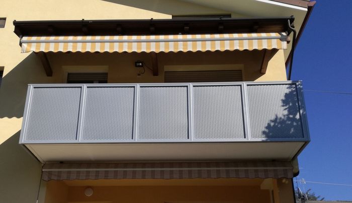 Un balcone con una tenda gialla e bianca