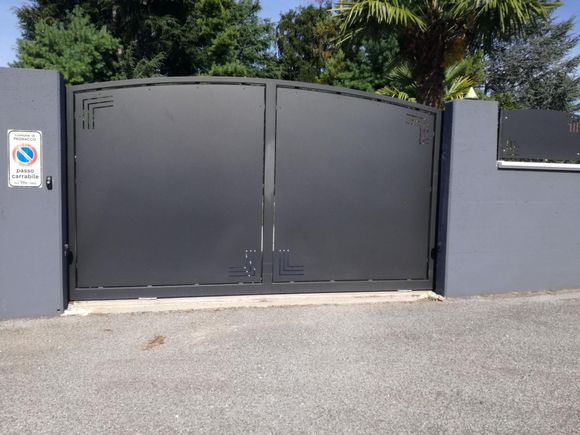 Un cancello nero con un cartello di divieto di parcheggio sul lato