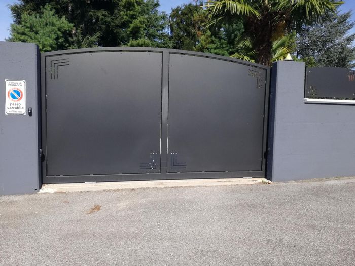 Un cancello nero con un cartello di divieto di parcheggio sul lato