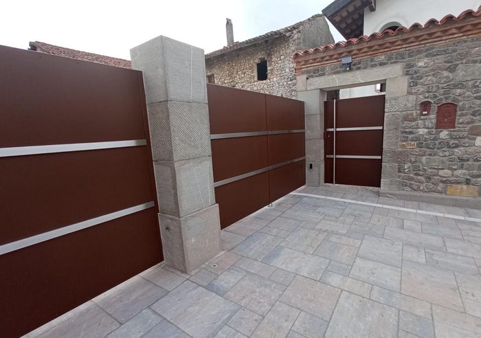 Un recinto marrone circonda un edificio in pietra