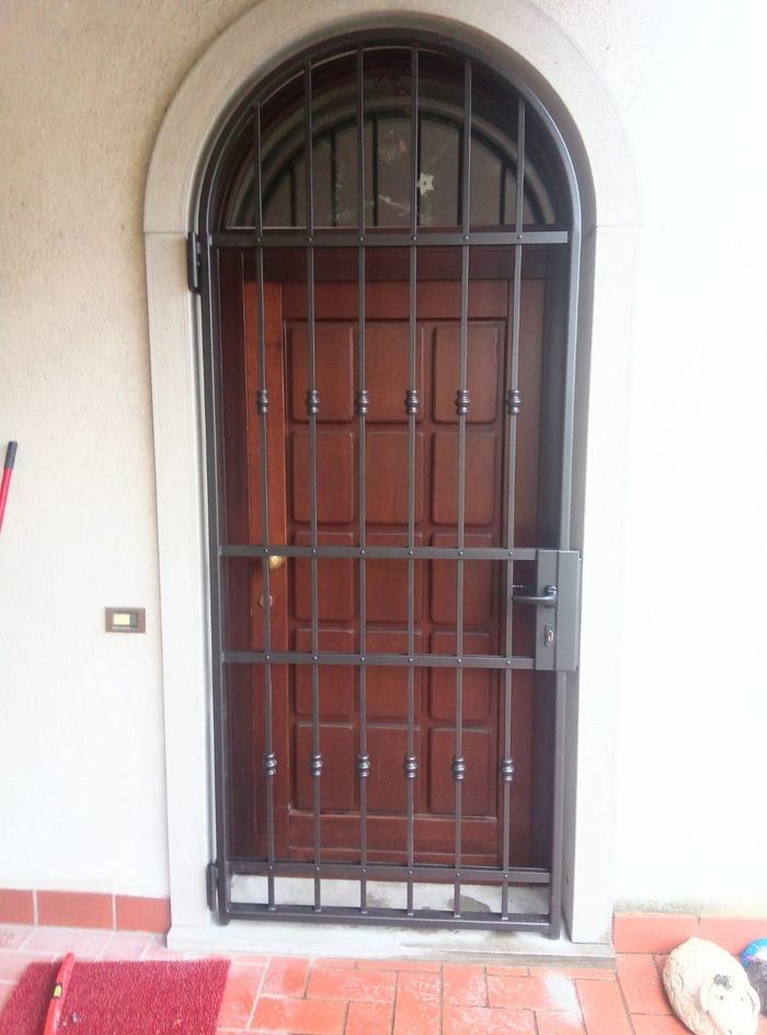 Una porta con una recinzione in ferro battuto attorno