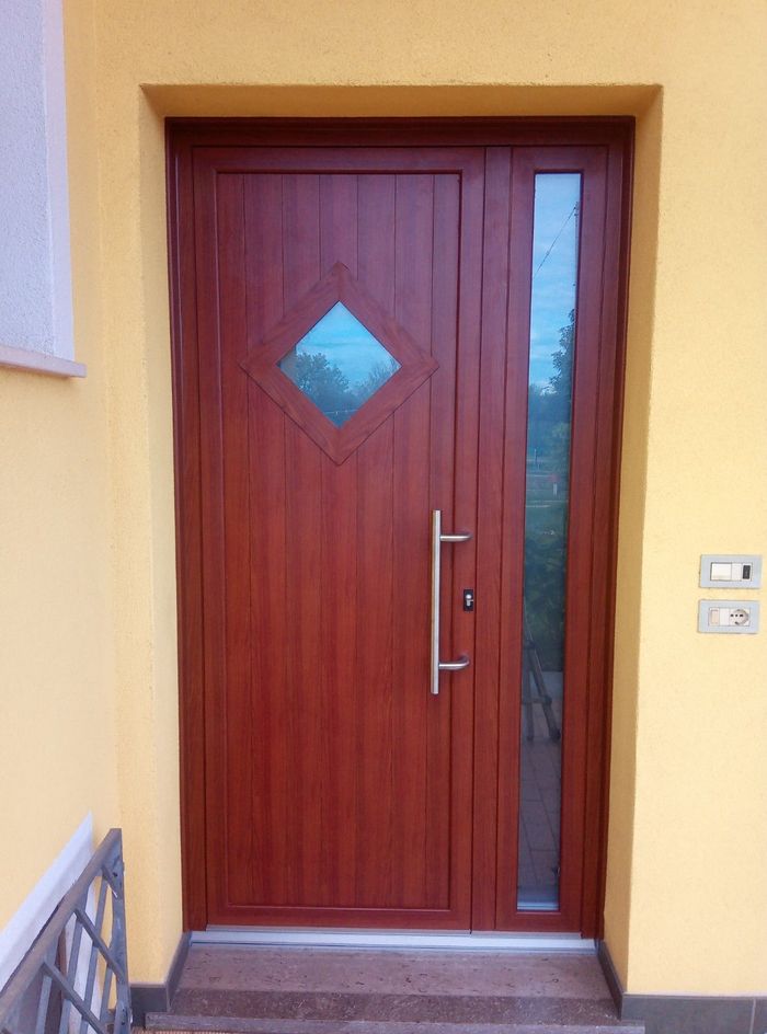 Una porta di legno con una finestra quadrata al centro