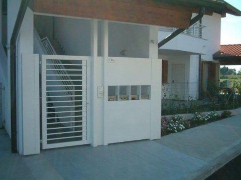 Una casa bianca con un cancello e delle scale davanti