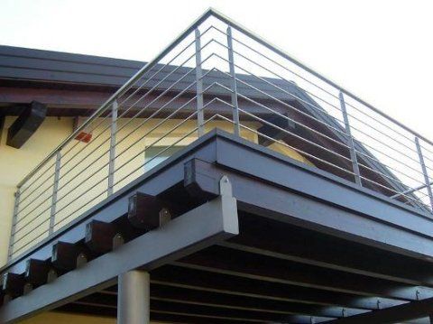 Un balcone con ringhiera in acciaio inox sul lato di una casa