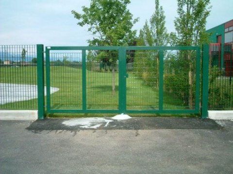 Un cancello verde è aperto su un campo erboso