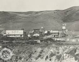 A black and white photo of a small town with mountains in the background.