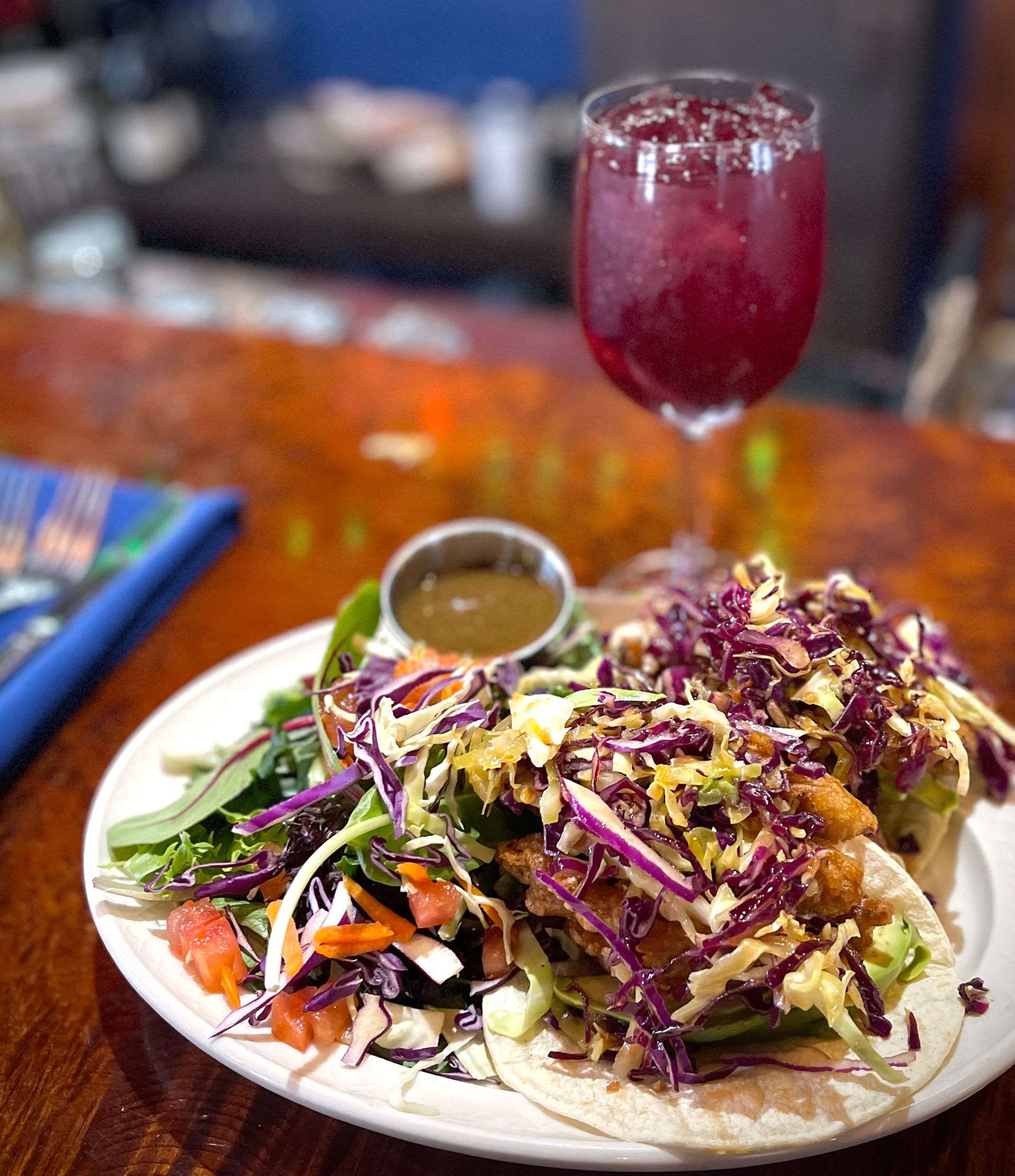 A plate of food with a glass of wine on a table.