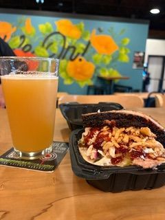 A plate of food and a glass of beer on a table.