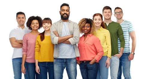 Group of seven people standing together against a white background, smiling with arms crossed.