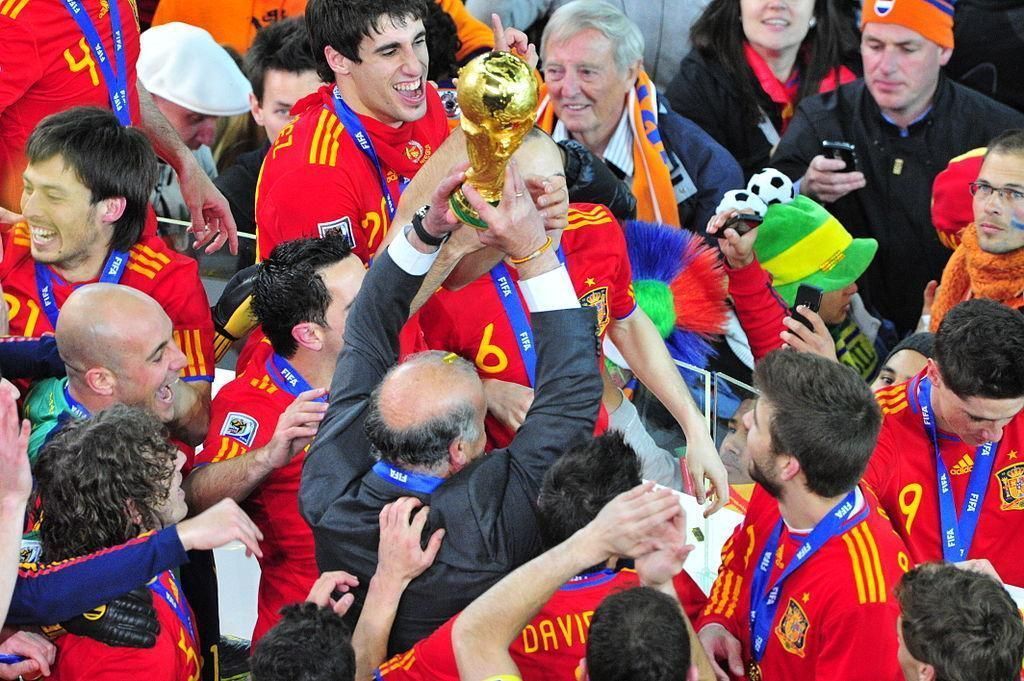 A group of soccer players are celebrating with a trophy