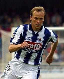 A man in a blue and white striped shirt with the word grafft on it