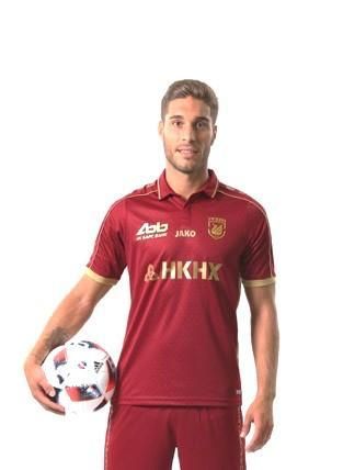 A man in a red shirt is holding a soccer ball.