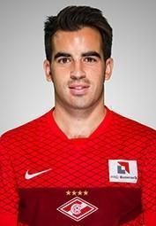 A man in a red soccer jersey is posing for a picture.