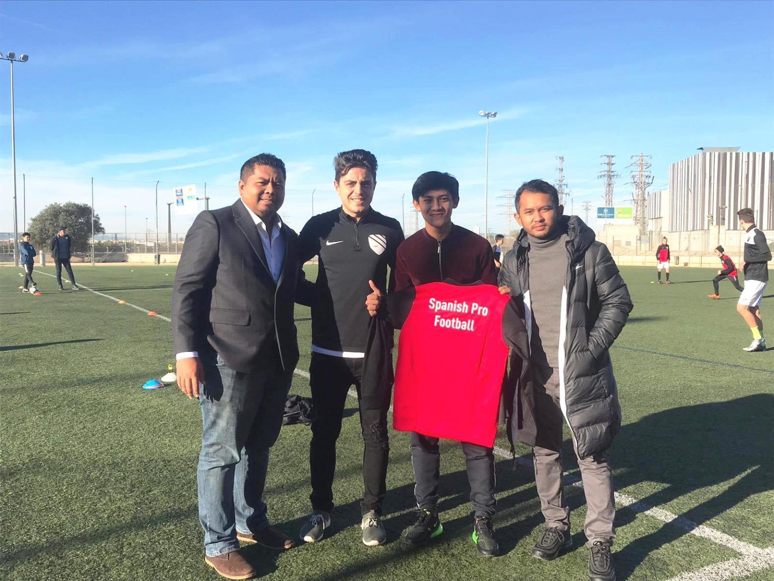 A group of men are posing for a picture on a soccer field.