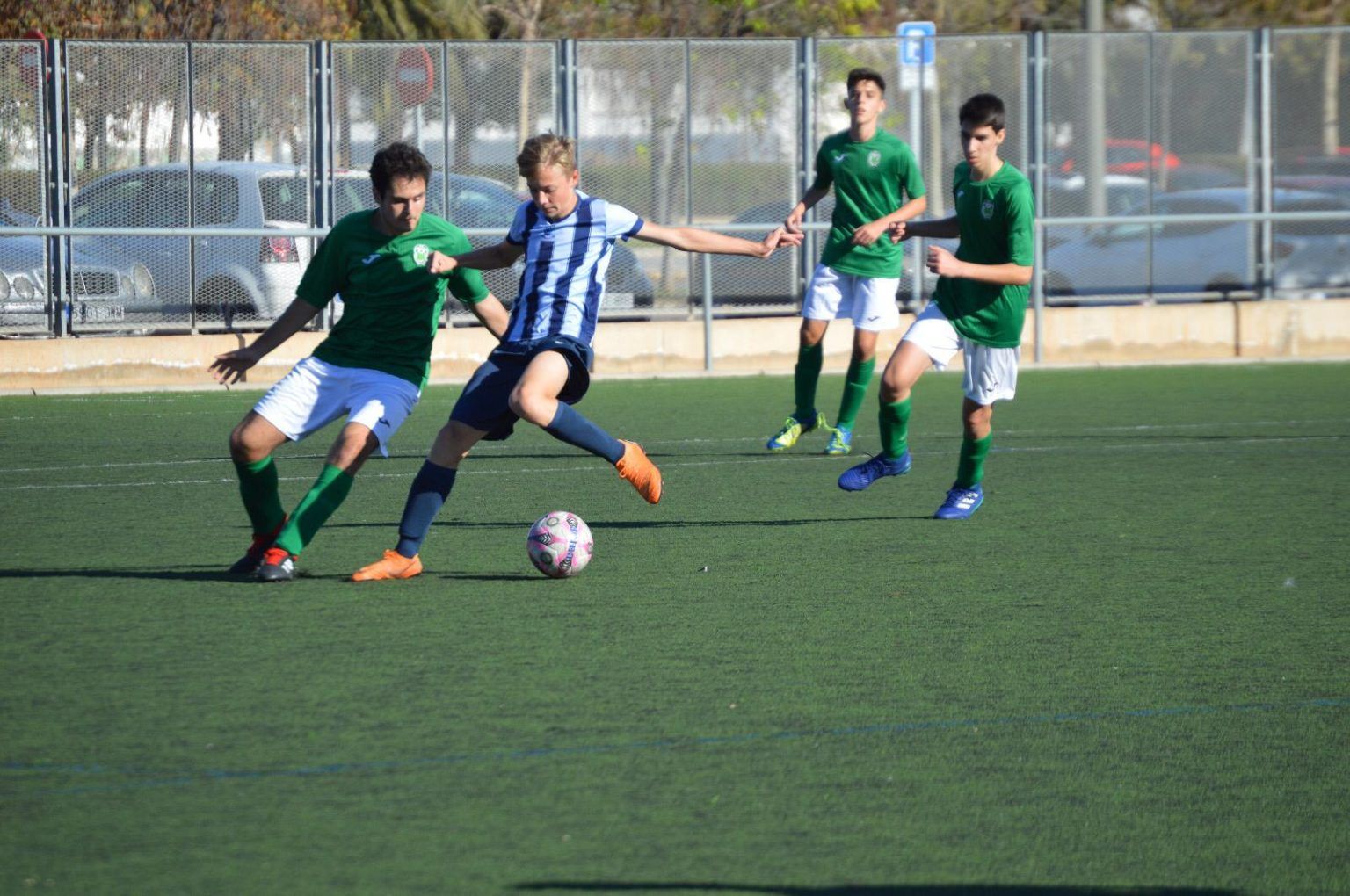A group of young men are playing soccer on a field.