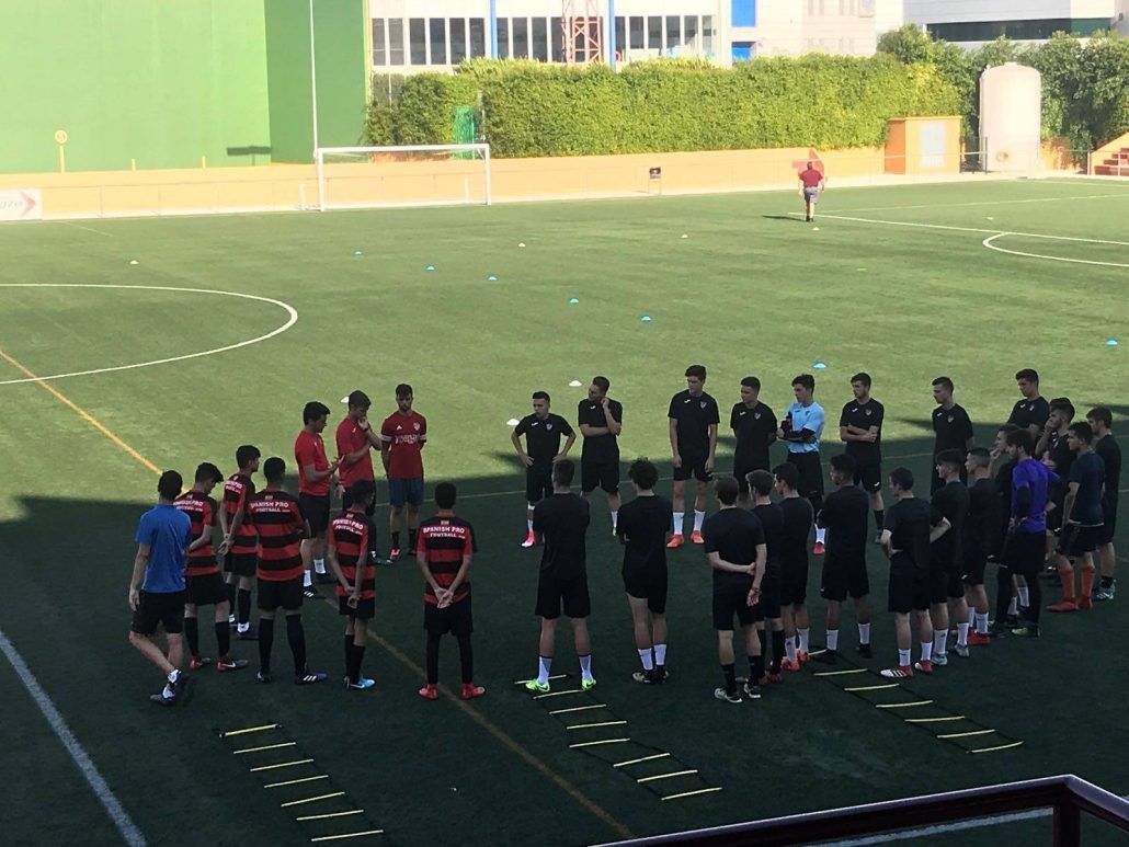 A group of people are standing in a circle on a soccer field.