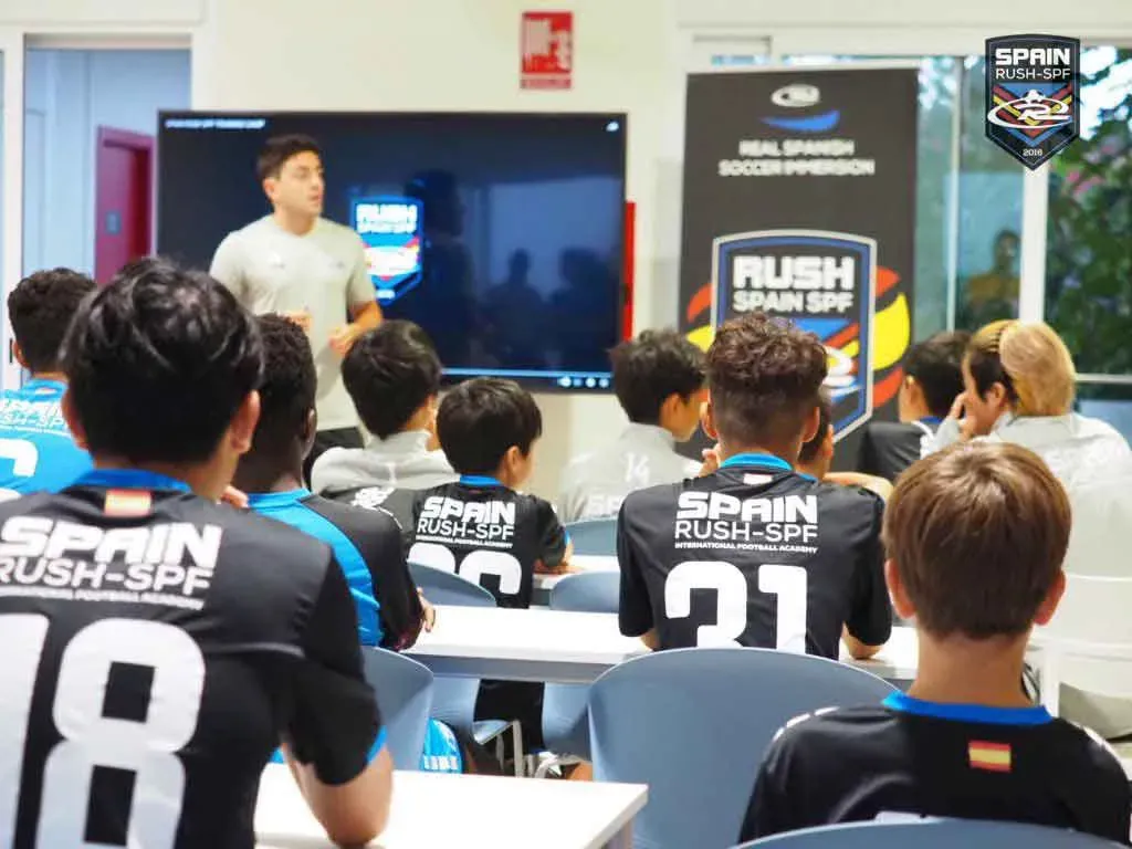 A group of young men are sitting in a classroom watching a presentation.