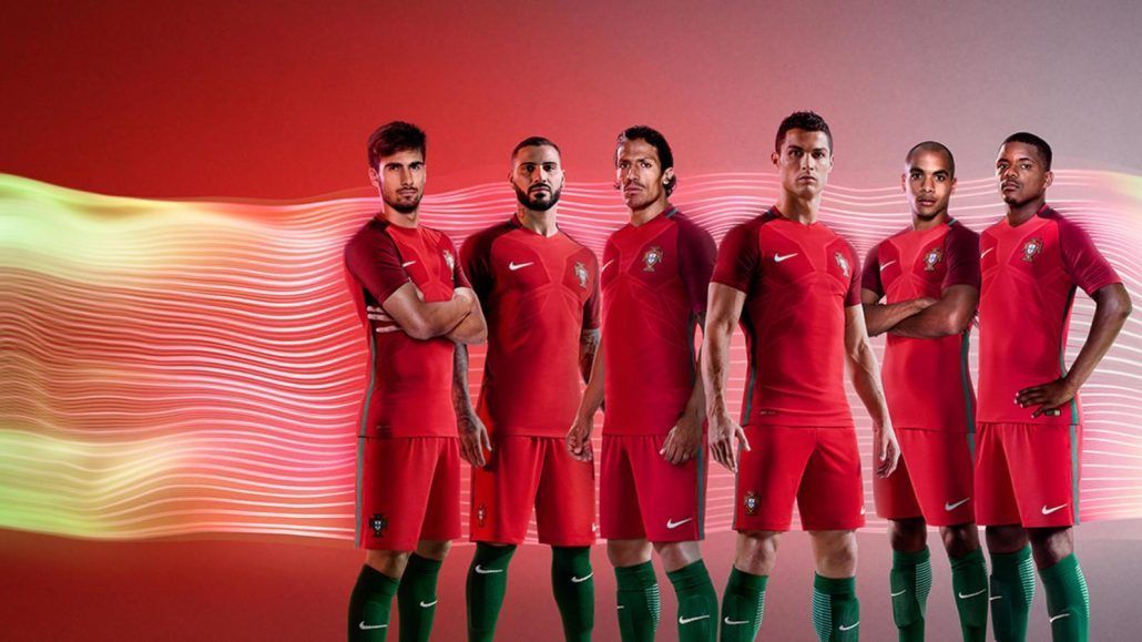 A group of soccer players are standing next to each other on a red background.