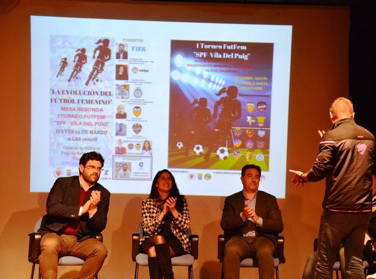 A group of people sitting in chairs in front of a large screen
