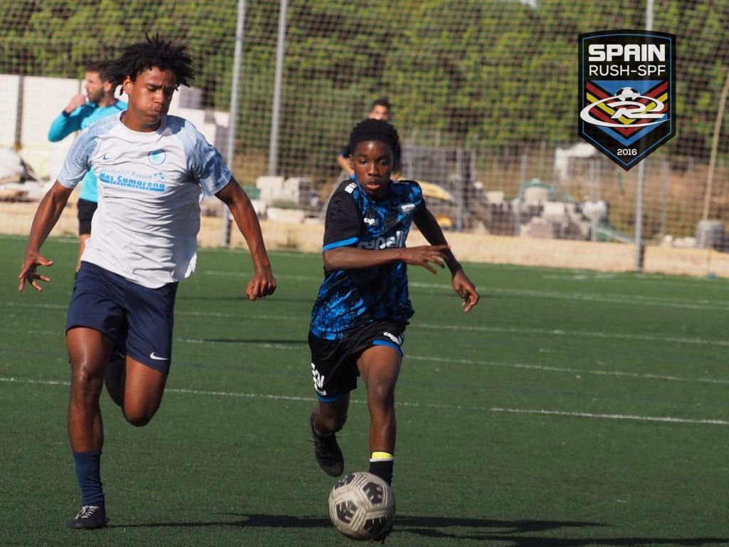 Two young men are playing soccer on a field.