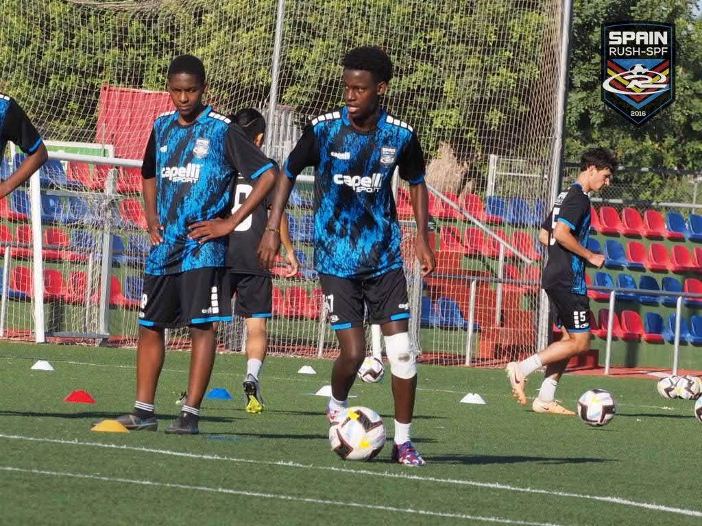 A group of young men are playing soccer on a field.