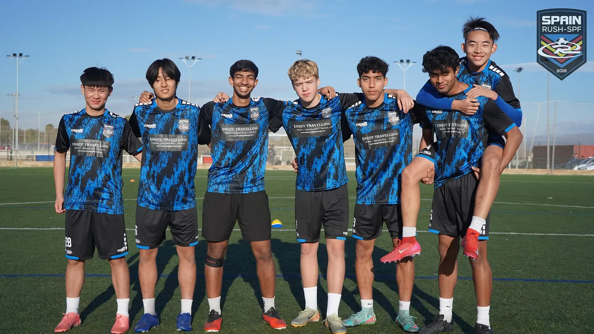 A group of young men are posing for a picture on a soccer field.