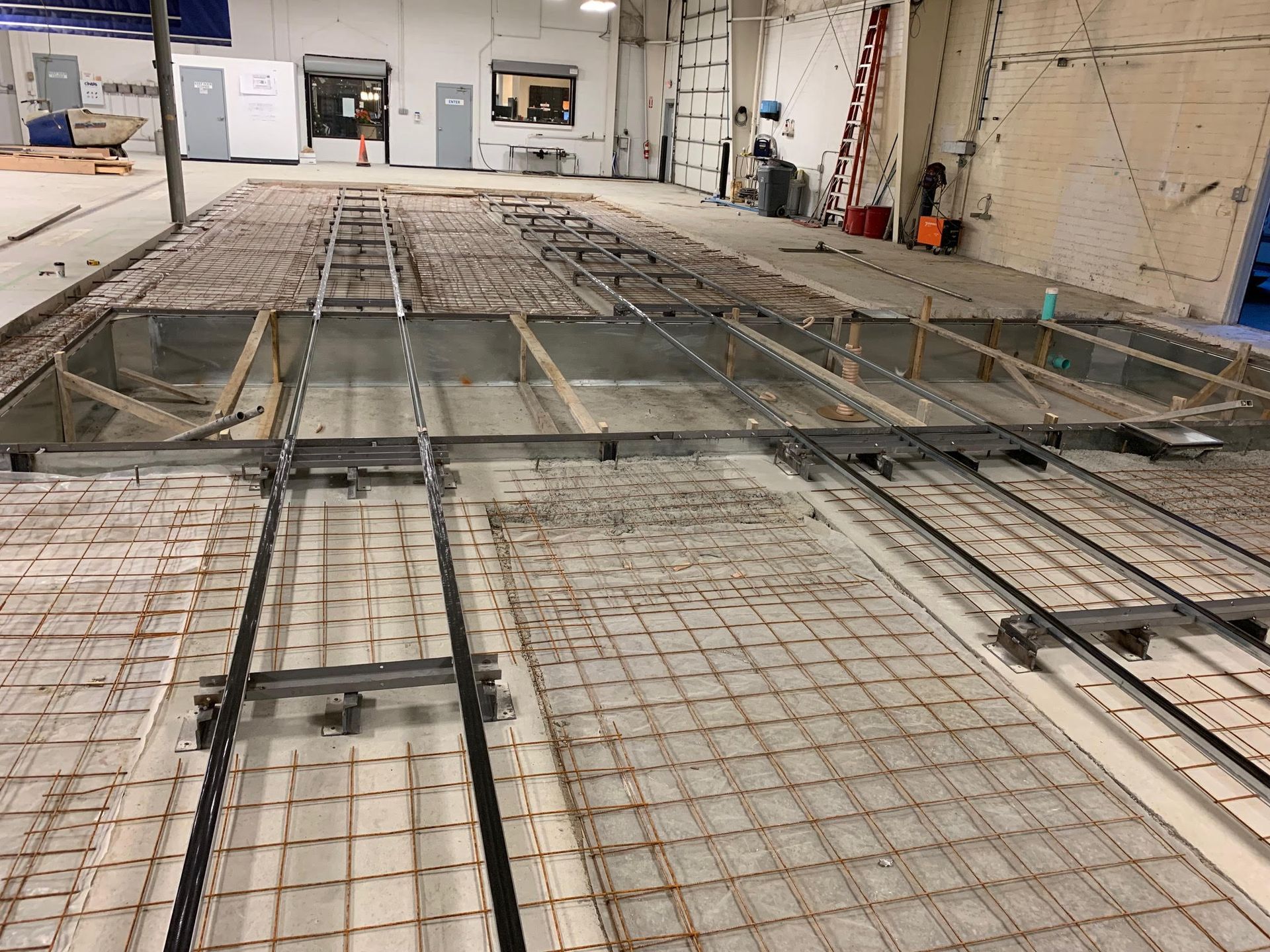 Construction site with metal framework and rebar prepared for concrete floor.