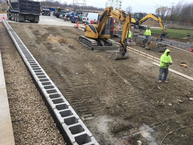 Freshly poured gray concrete walkway at a construction site.