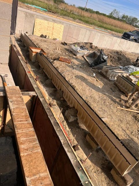 Construction site: wooden forms set in trench, awaiting concrete.