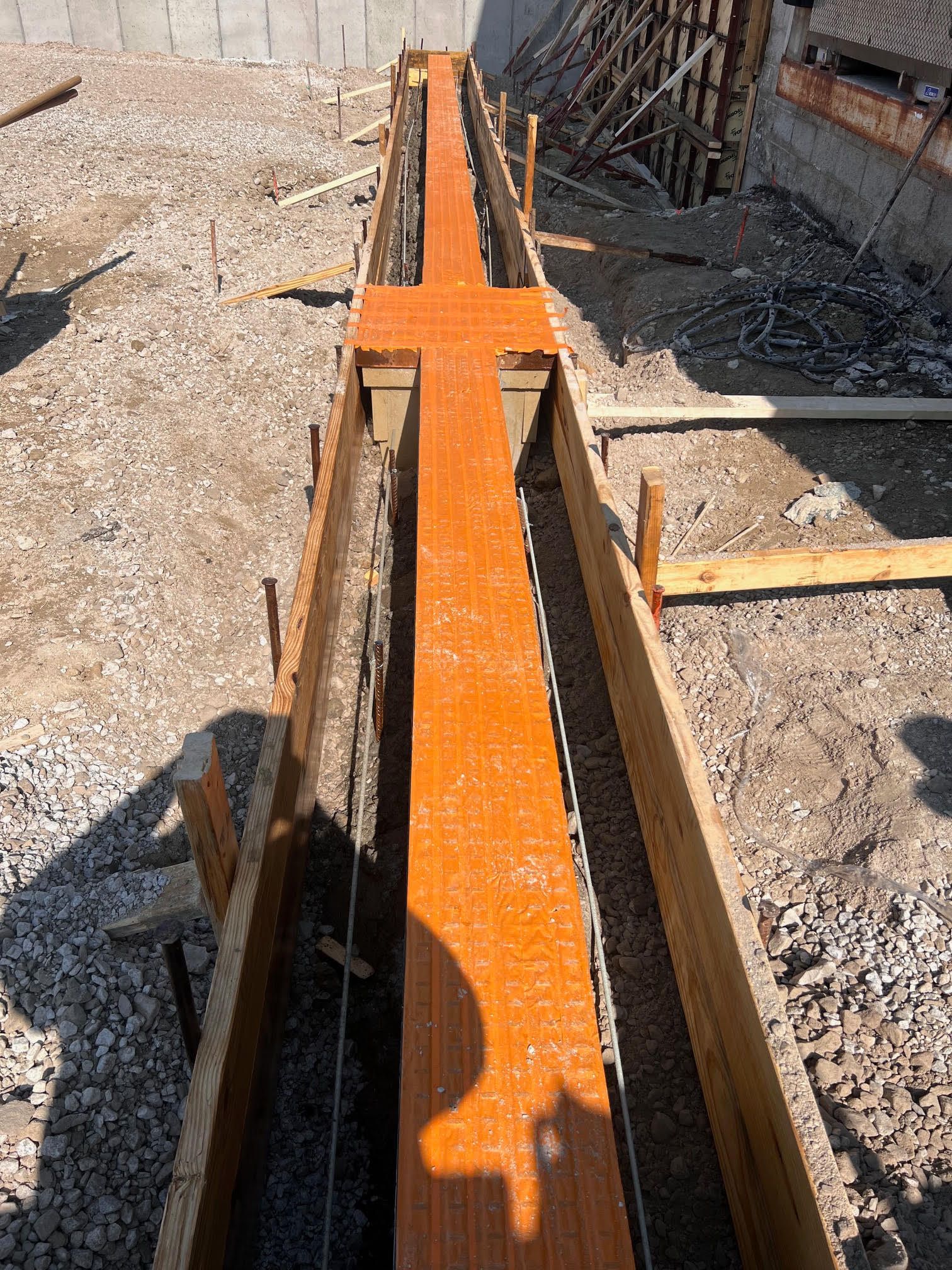 Formwork for a concrete beam, with orange top section and rebar visible.