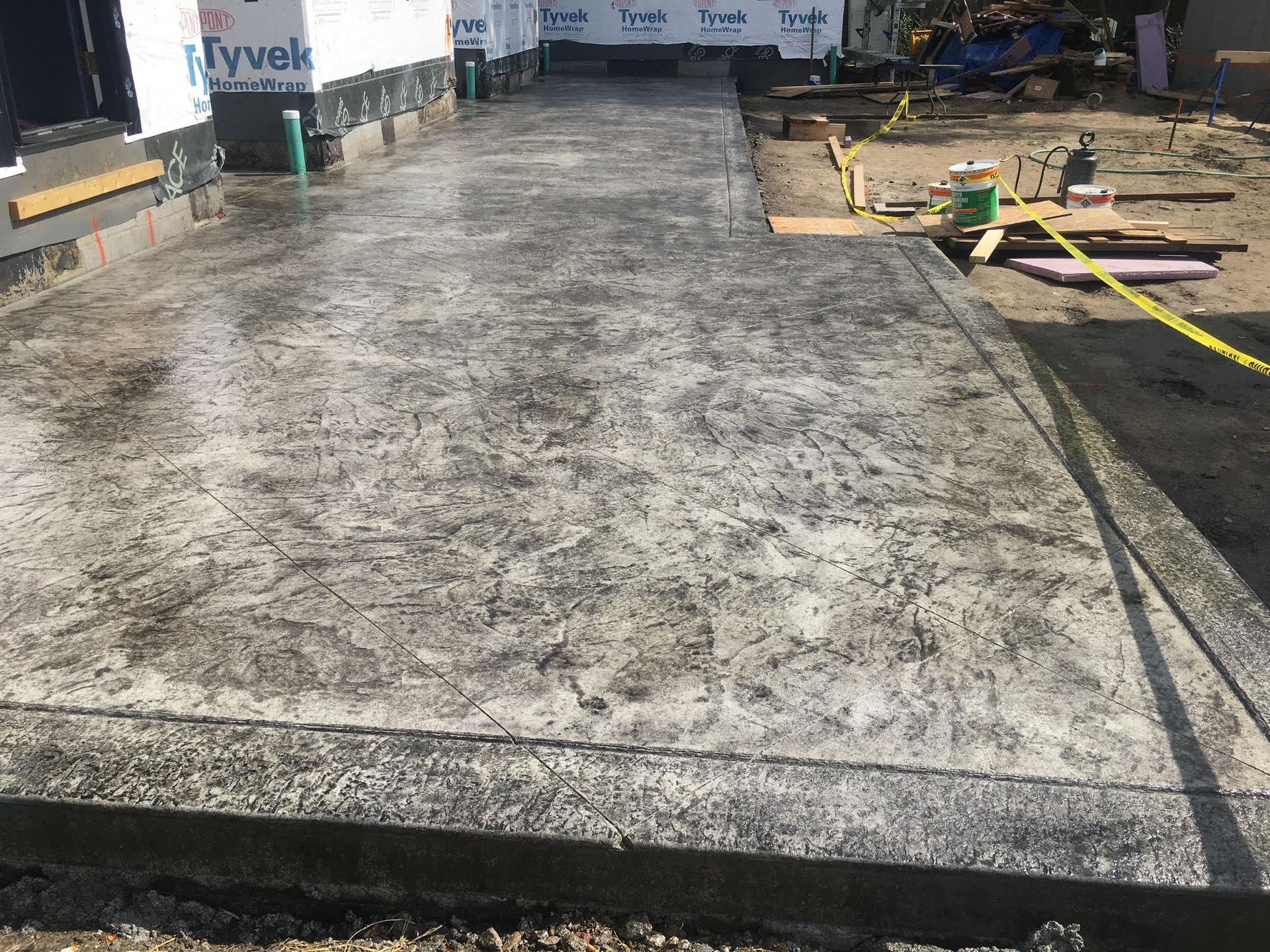 Finished concrete walkway with textured surface at a construction site.