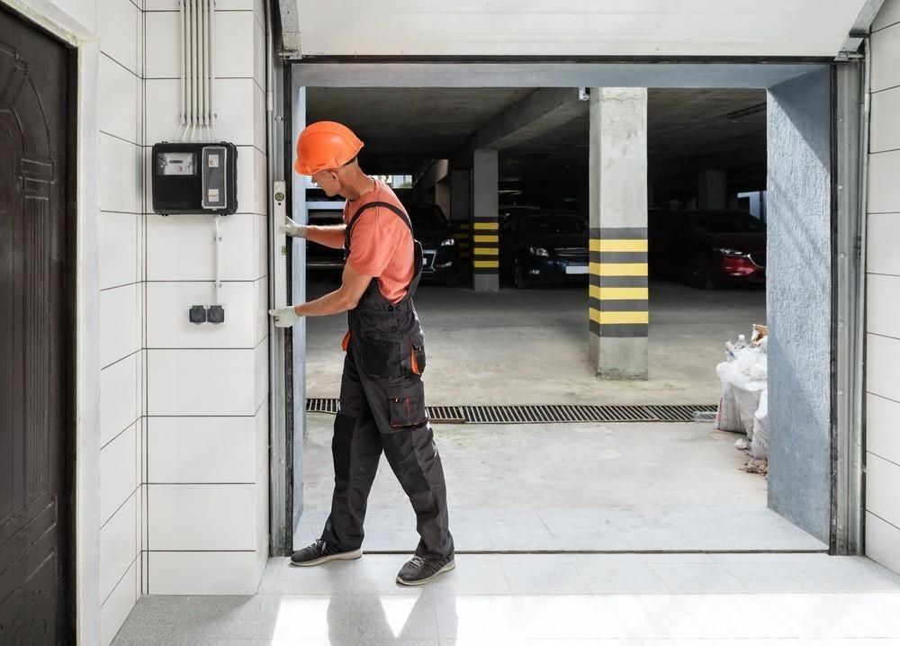 a man is opening a garage door in a parking garage .