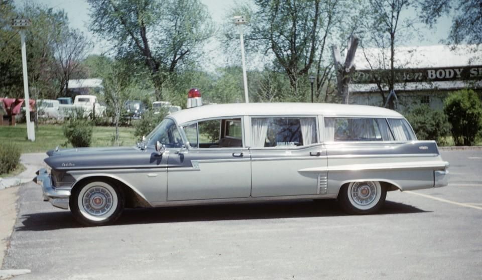 Classic silver vintage station wagon parked outdoors on a sunny day.