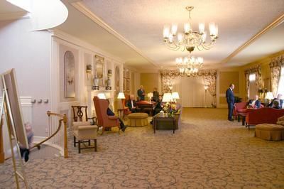 Elegant hotel lobby with chandeliers, carpeted seating areas, and warm lighting