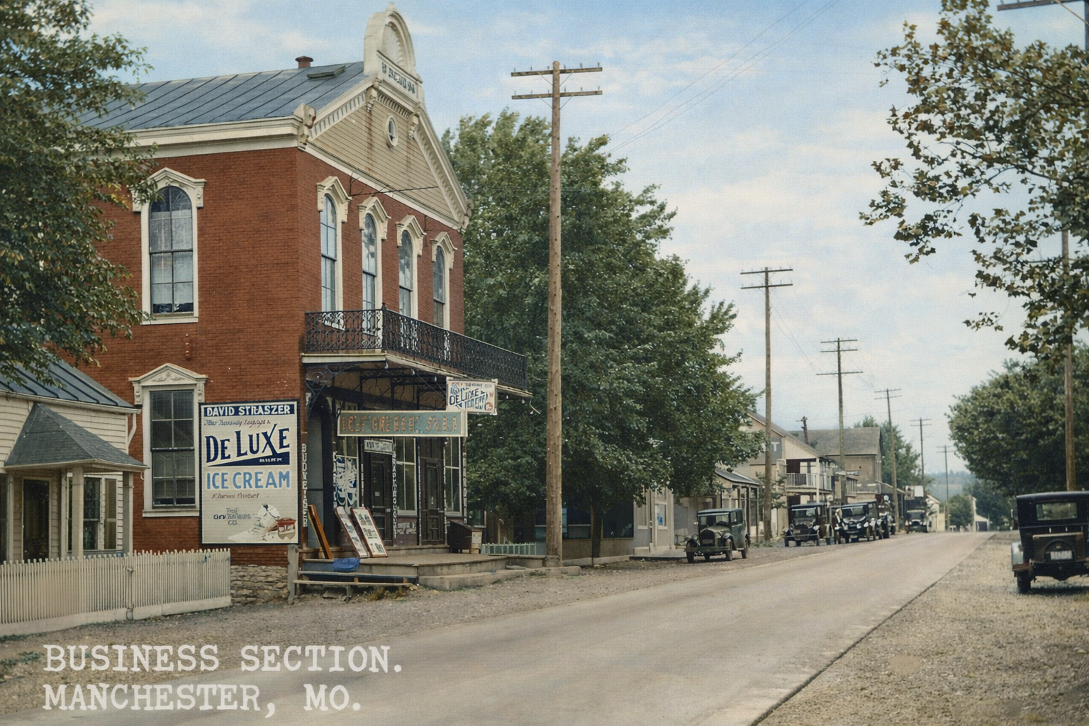 Historic downtown street in Manchester, Missouri, with a red brick storefront and parked cars