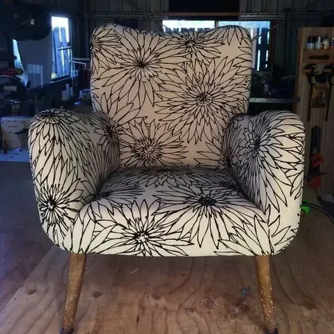A Chair With a Floral Pattern is on a Wooden Floor in a Room — Paulie's Upholstery in Edmonton, QLD